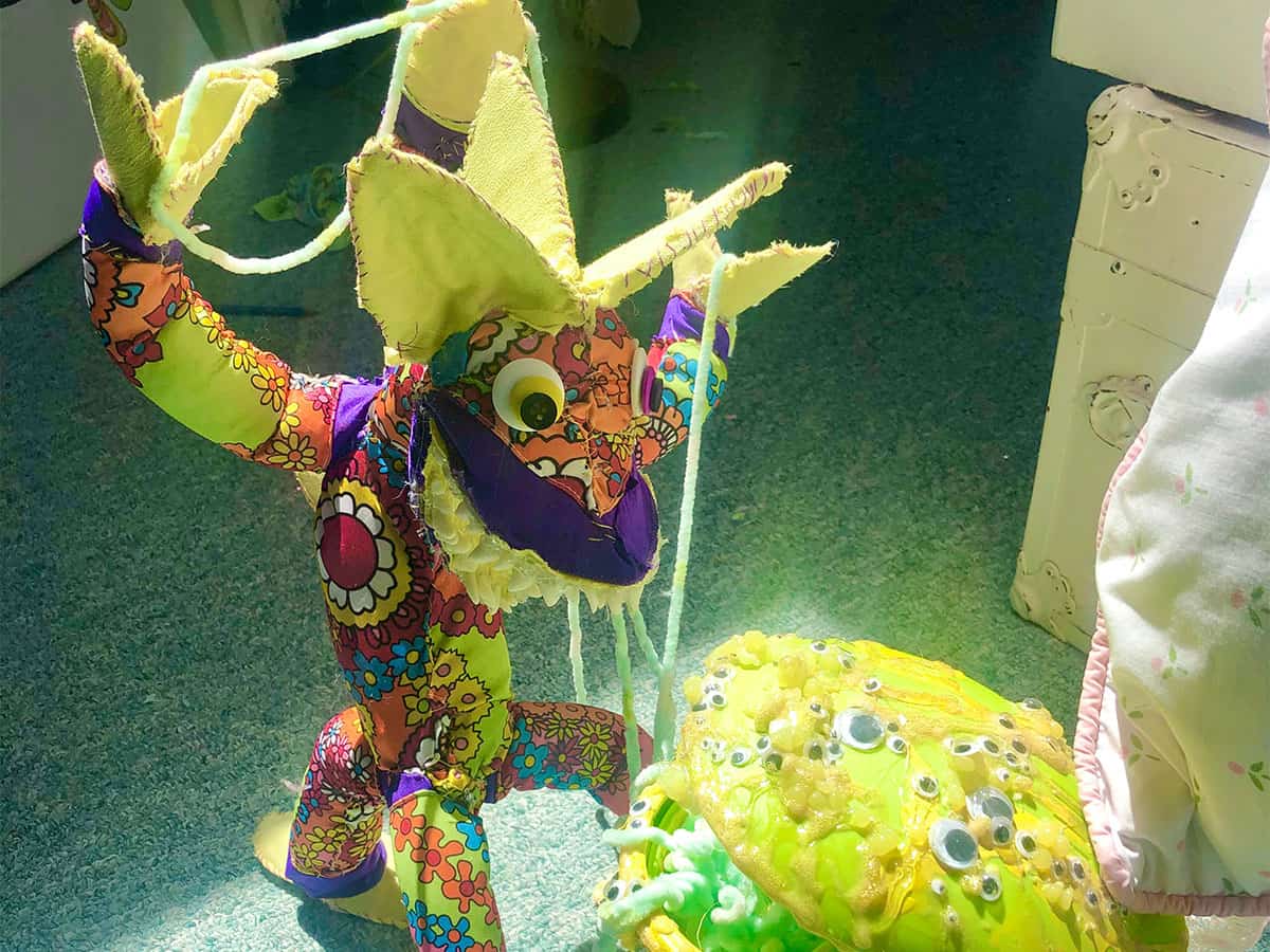 animal-like doll made of colorful fabric with reptilian face and 6 arms