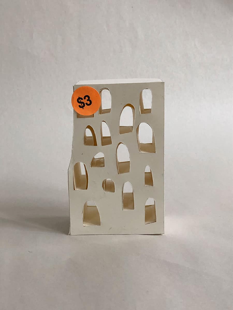 cardstock model with arch-like holes cut in walls and a $3 sticker